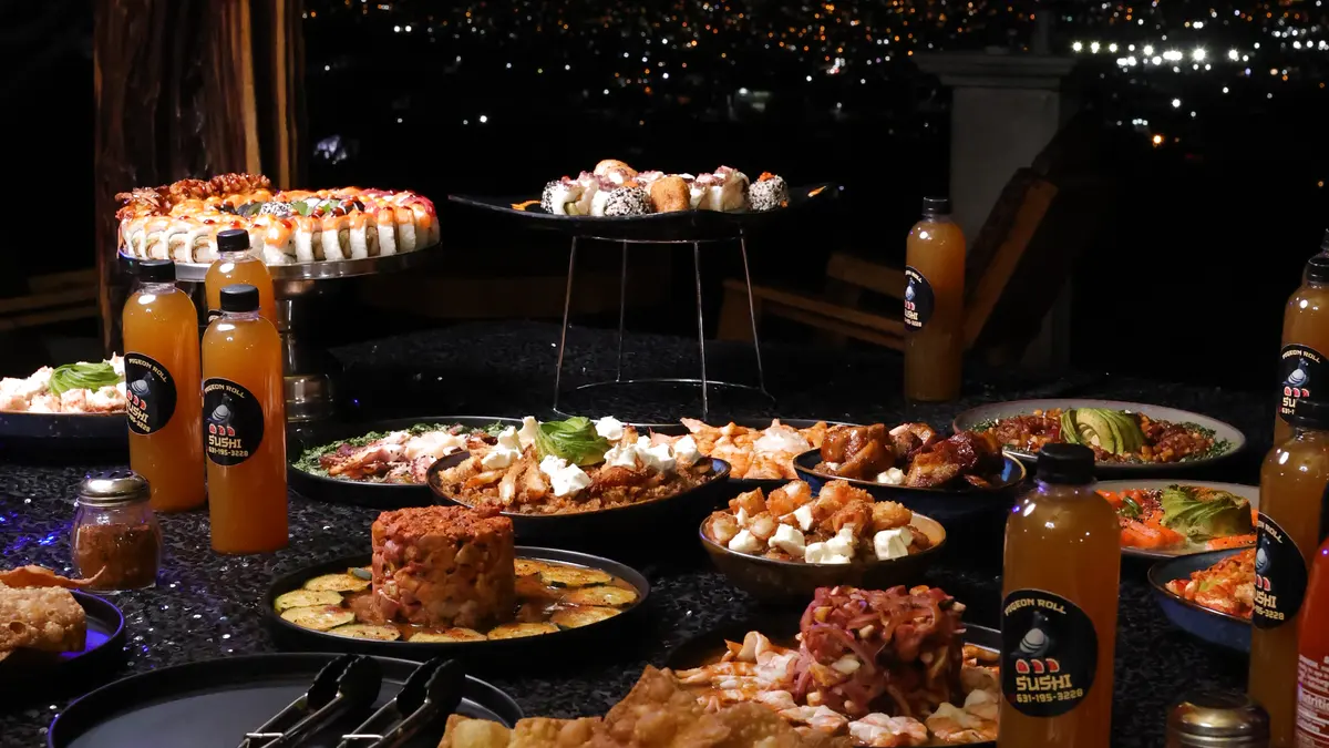 Banquete de Pigeon Roll en un evento de noche, con la ciudad iluminada al fondo
